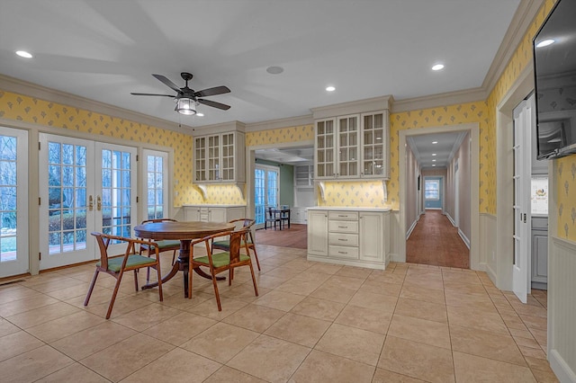 dining area with ceiling fan, light tile patterned floors, ornamental molding, and french doors