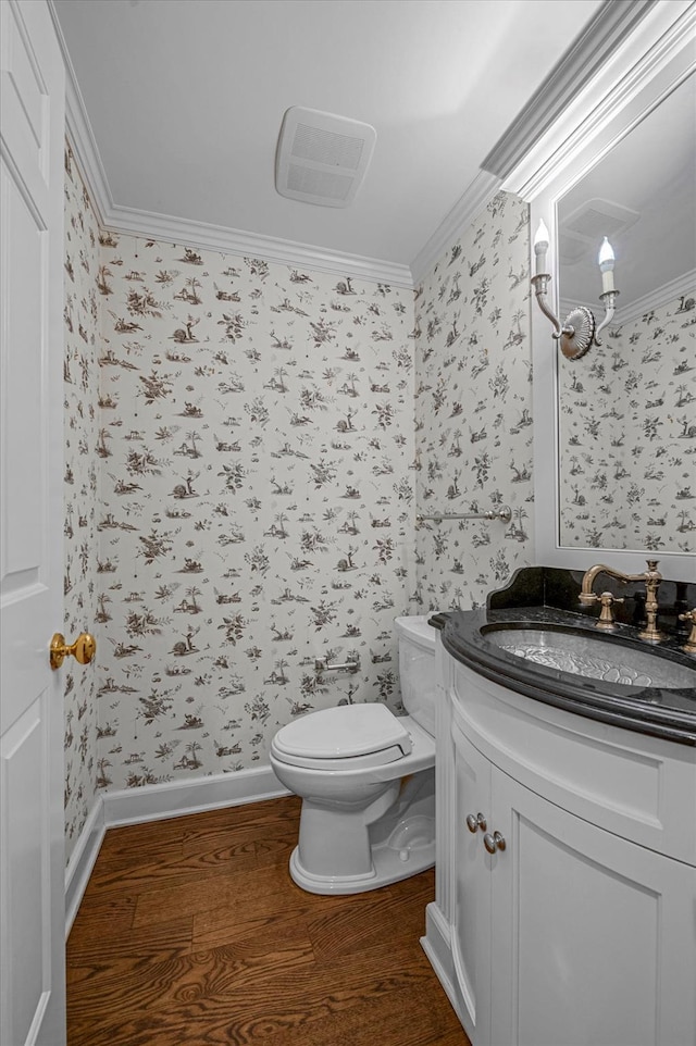 bathroom with toilet, vanity, ornamental molding, and hardwood / wood-style floors