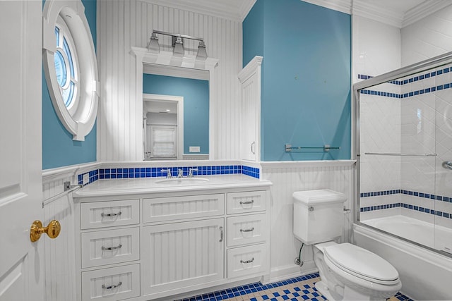 full bathroom with toilet, combined bath / shower with glass door, tile patterned floors, ornamental molding, and vanity