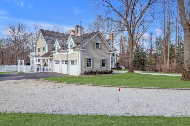 view of side of property featuring a garage and a lawn