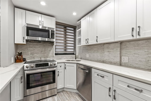 kitchen with appliances with stainless steel finishes, sink, and white cabinetry