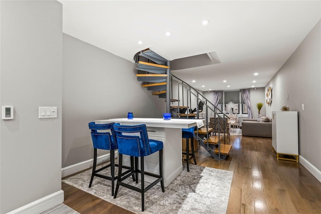 interior space featuring a kitchen breakfast bar and dark hardwood / wood-style flooring