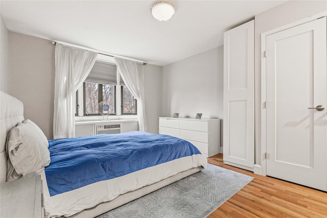 bedroom featuring a wall mounted air conditioner and hardwood / wood-style floors