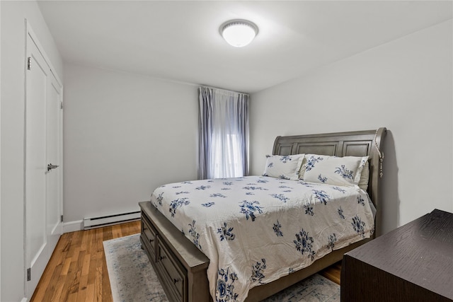 bedroom with hardwood / wood-style flooring and a baseboard radiator