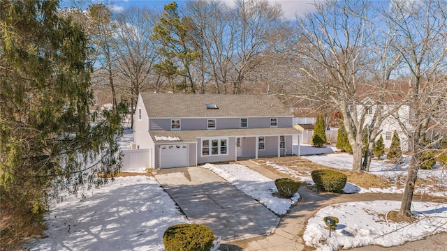 view of front of house with driveway, an attached garage, and fence