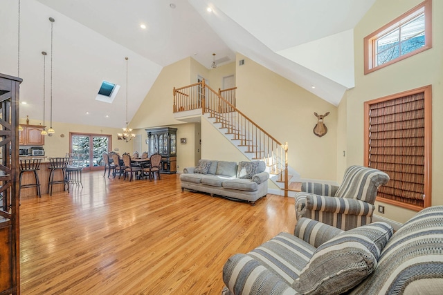 living room with high vaulted ceiling, light hardwood / wood-style flooring, and plenty of natural light