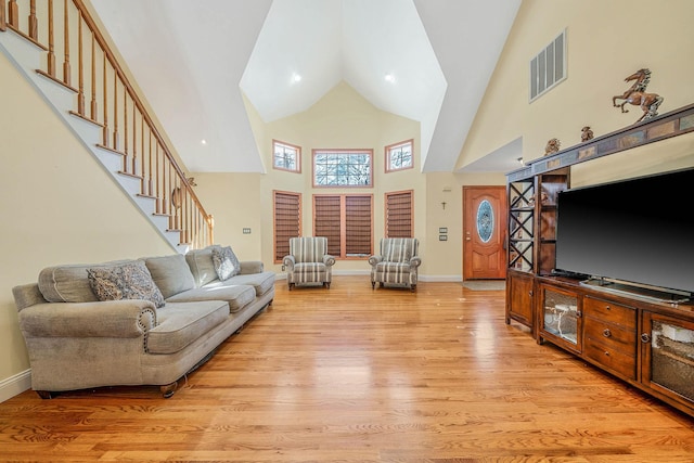 living room with a high ceiling and light wood-type flooring