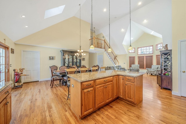 kitchen featuring light hardwood / wood-style floors, a center island, pendant lighting, and a breakfast bar