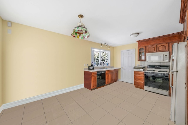 kitchen with hanging light fixtures, sink, light tile patterned floors, white appliances, and decorative backsplash