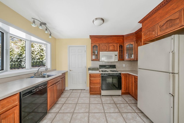 kitchen featuring sink, white appliances, and backsplash