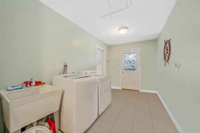 clothes washing area featuring sink, separate washer and dryer, and light tile patterned flooring