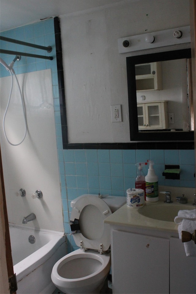 full bathroom featuring bathtub / shower combination, tile walls, toilet, and vanity