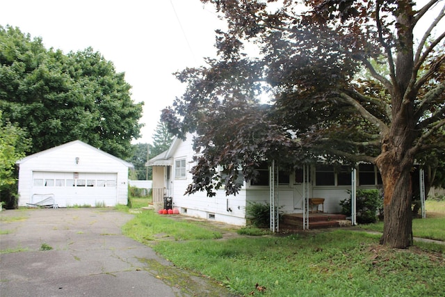 view of front of house featuring a garage and an outbuilding