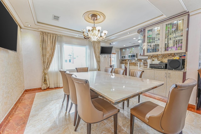 dining room featuring a notable chandelier, crown molding, and a raised ceiling