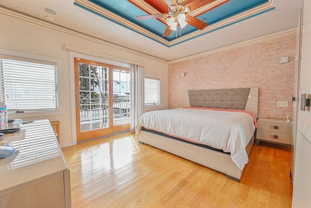 bedroom featuring crown molding, light hardwood / wood-style flooring, a raised ceiling, ceiling fan, and access to exterior