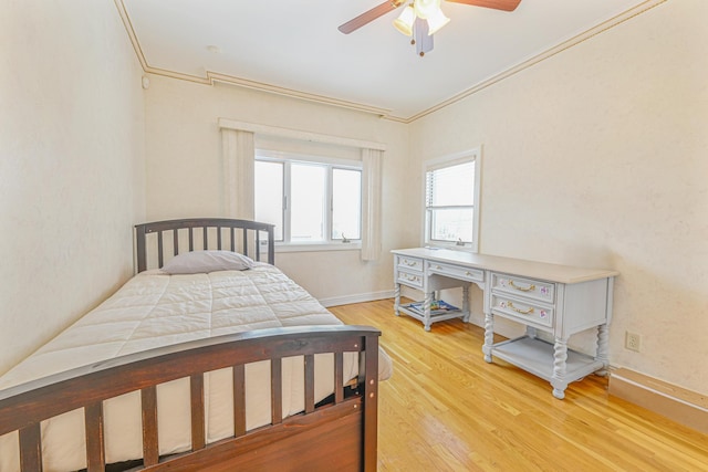 bedroom with crown molding, hardwood / wood-style flooring, and ceiling fan