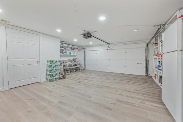 garage with white refrigerator and a garage door opener