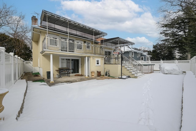 snow covered property featuring a balcony