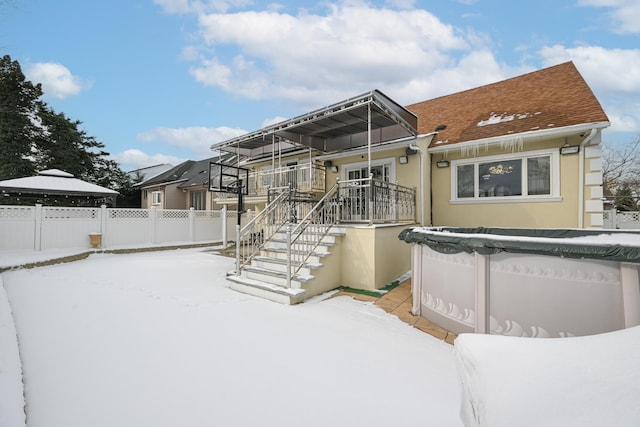 snow covered property featuring a gazebo and a covered pool