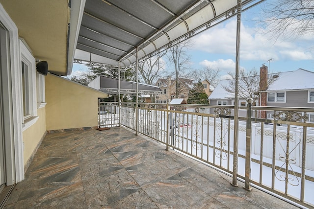 snow covered patio with a balcony