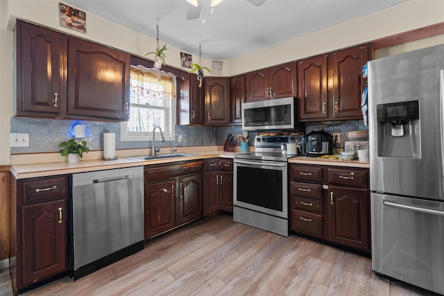 kitchen with tasteful backsplash, sink, dark brown cabinetry, stainless steel appliances, and light wood-type flooring