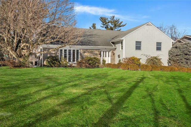 rear view of property featuring a yard