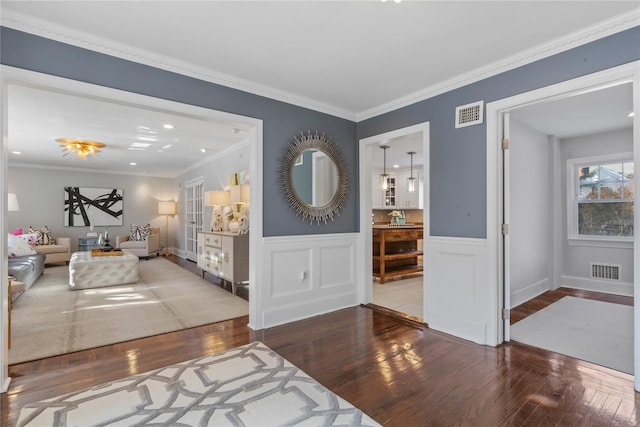 foyer entrance featuring wood-type flooring and crown molding