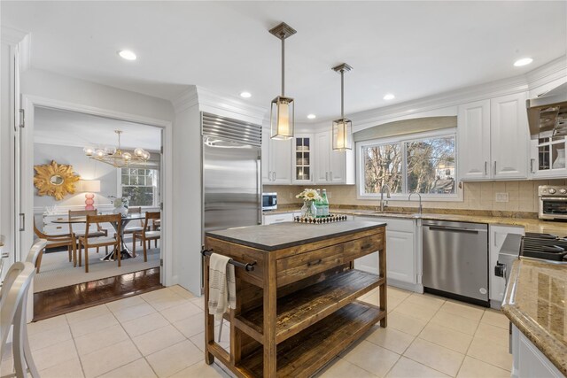 kitchen featuring light tile patterned floors, white cabinetry, stainless steel appliances, and decorative backsplash