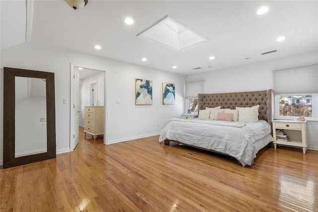 bedroom with light wood-style floors, a skylight, visible vents, and recessed lighting