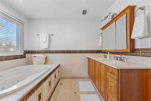 full bath featuring double vanity, visible vents, tile patterned floors, a whirlpool tub, and a sink