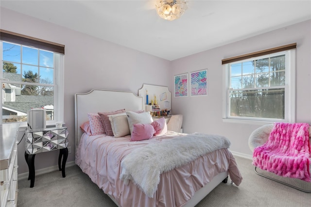 bedroom featuring light carpet, baseboards, and multiple windows