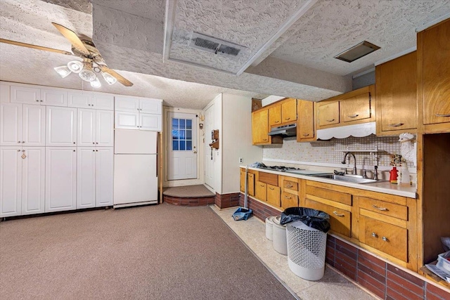 kitchen featuring sink, tasteful backsplash, gas cooktop, white fridge, and ceiling fan