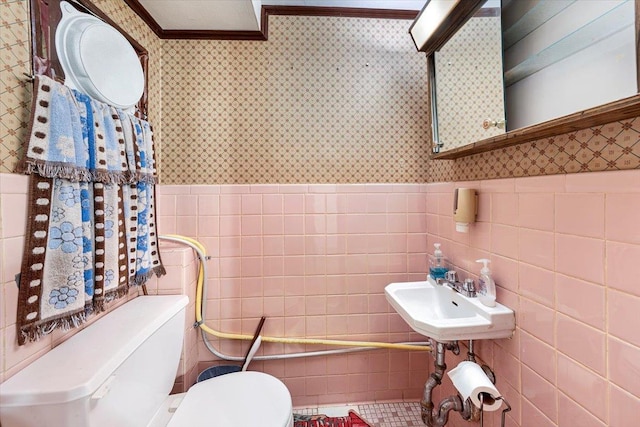 bathroom featuring sink, tile walls, and toilet