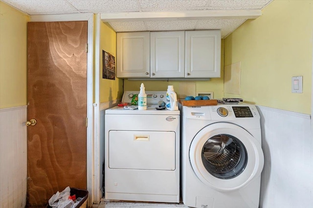 clothes washing area featuring cabinets and washer and dryer