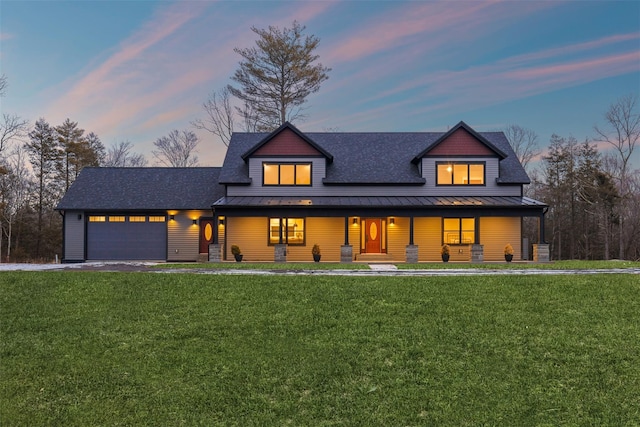 view of front of home featuring a lawn, a porch, and a garage