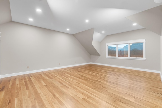 bonus room featuring lofted ceiling and light hardwood / wood-style flooring