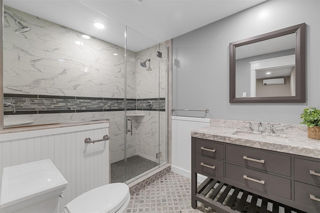 bathroom with an AC wall unit, toilet, a shower with door, and vanity