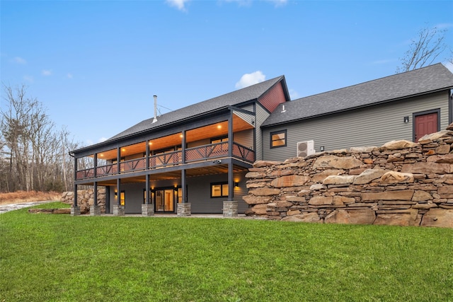 rear view of house featuring a deck and a yard