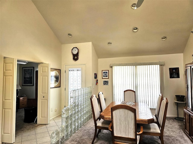 dining space with lofted ceiling and light carpet