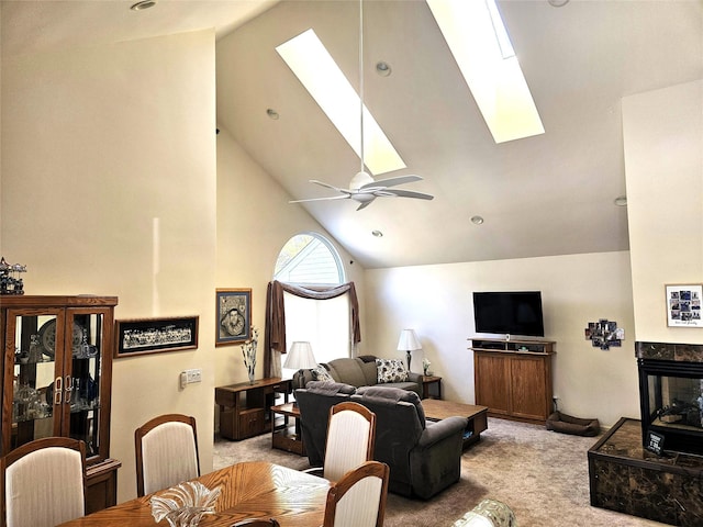 living room with light carpet, ceiling fan, and a skylight