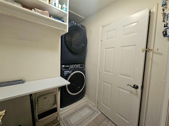 clothes washing area with stacked washer and clothes dryer and light tile patterned floors