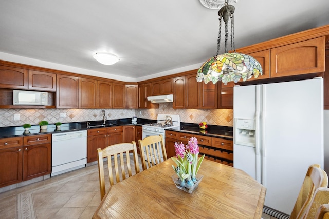 kitchen featuring light tile patterned floors, backsplash, decorative light fixtures, white appliances, and sink