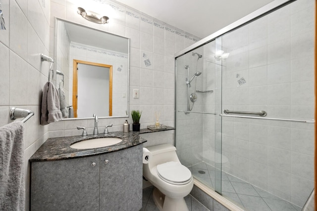 bathroom with toilet, backsplash, tile walls, walk in shower, and vanity