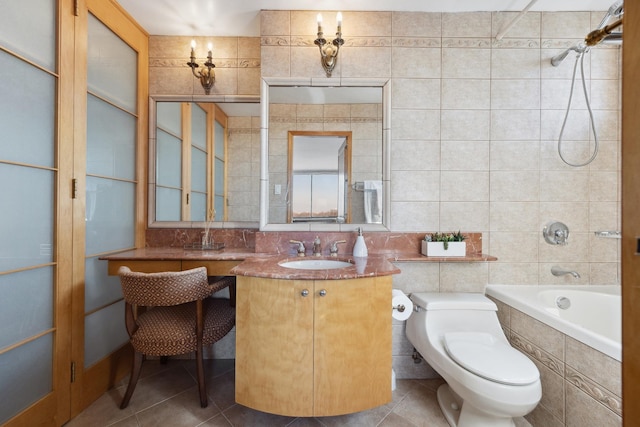 full bathroom featuring toilet, tiled shower / bath, tile patterned flooring, tile walls, and vanity