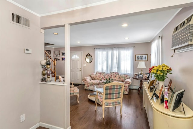 living room with an AC wall unit, baseboard heating, dark wood-type flooring, and crown molding