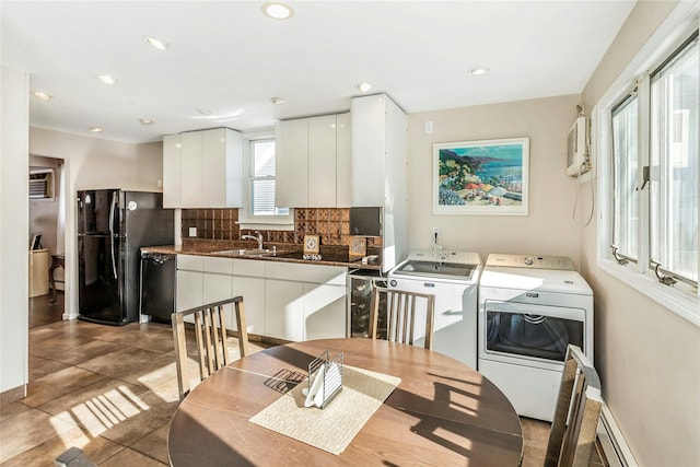 dining space featuring separate washer and dryer, baseboard heating, tile patterned floors, and sink