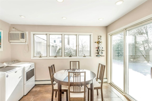 washroom with washer and clothes dryer, a baseboard heating unit, an AC wall unit, and light tile patterned floors