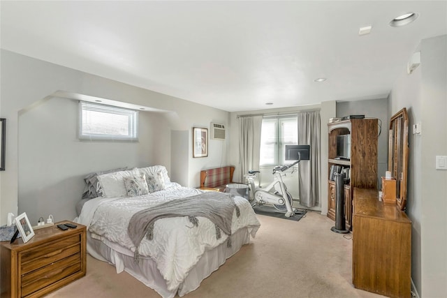 bedroom featuring light carpet and a wall mounted air conditioner