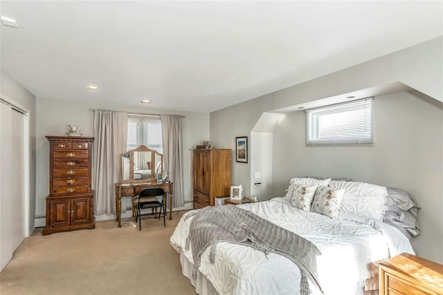 bedroom with baseboard heating and light carpet