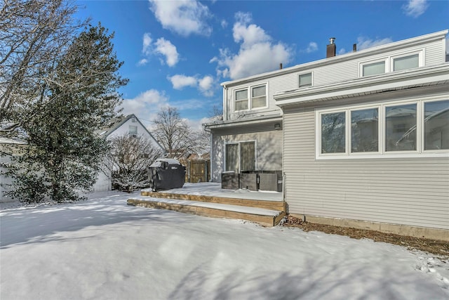 snow covered rear of property featuring a wooden deck